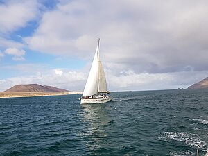 Segelyacht mit einer kargen Insel im Hintergrund