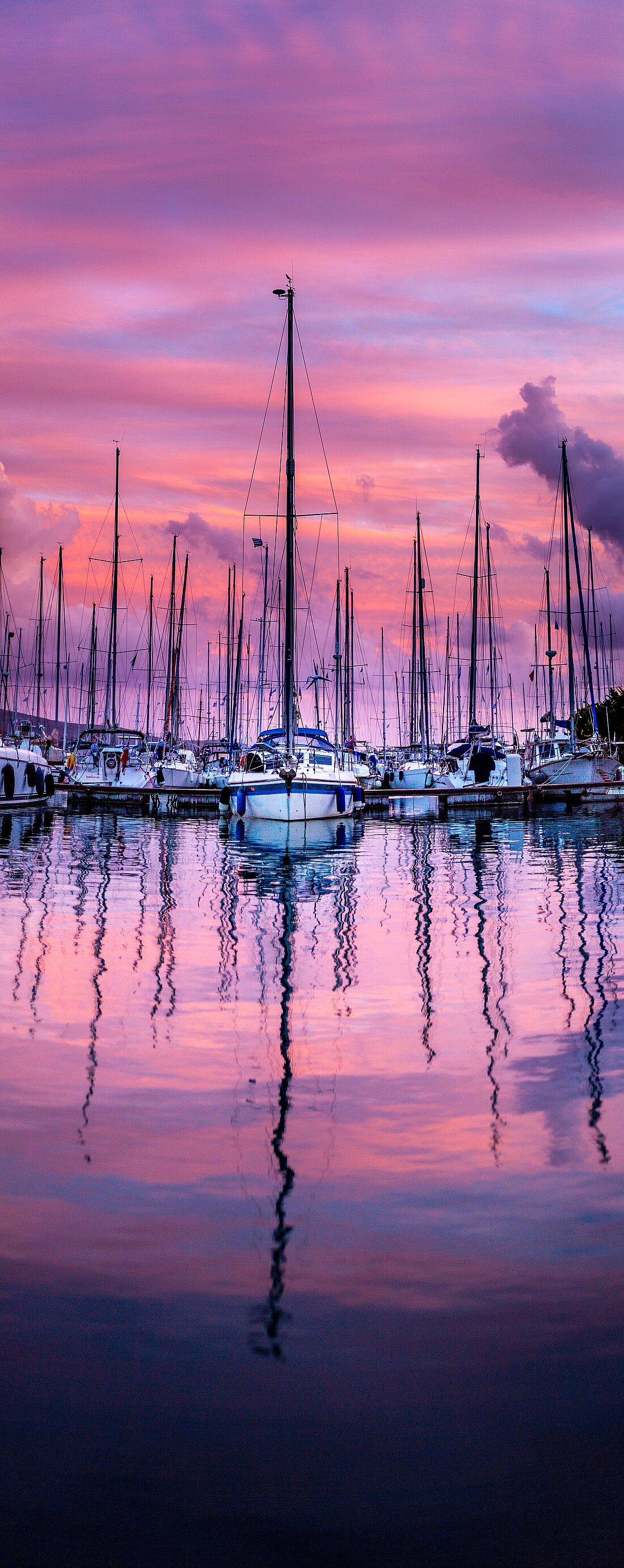 Blick von der Segelyacht auf Boote im Wasser bei romantischem Sonnenuntergang