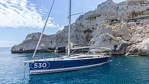 Dufour 530 Segelyacht ankert vor Felsküste