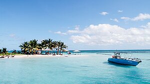 Yacht in paradiesisch klarem, blauem Wasser vor der Küste mit Palmen von Guadeloupe Yacht in paradiesisch klarem, blauem Wasser vor der Küste mit Palmen von Guadeloupe