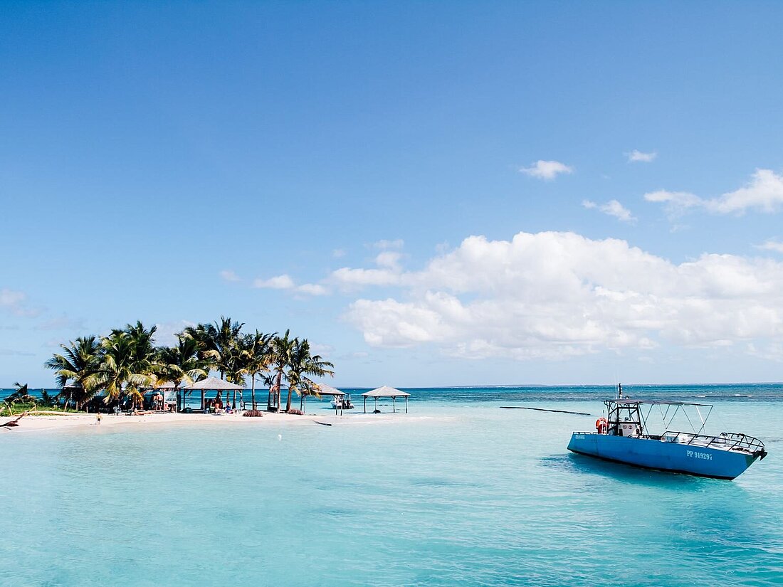 Yacht in paradiesisch klarem, blauem Wasser vor der Küste mit Palmen von Guadeloupe Yacht in paradiesisch klarem, blauem Wasser vor der Küste mit Palmen von Guadeloupe