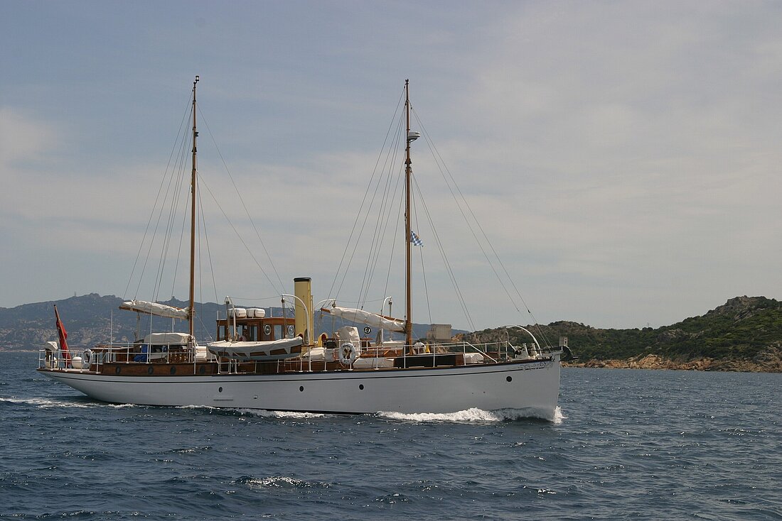 klassische Motoryacht fährt unter Motor an einer Insel vorbei