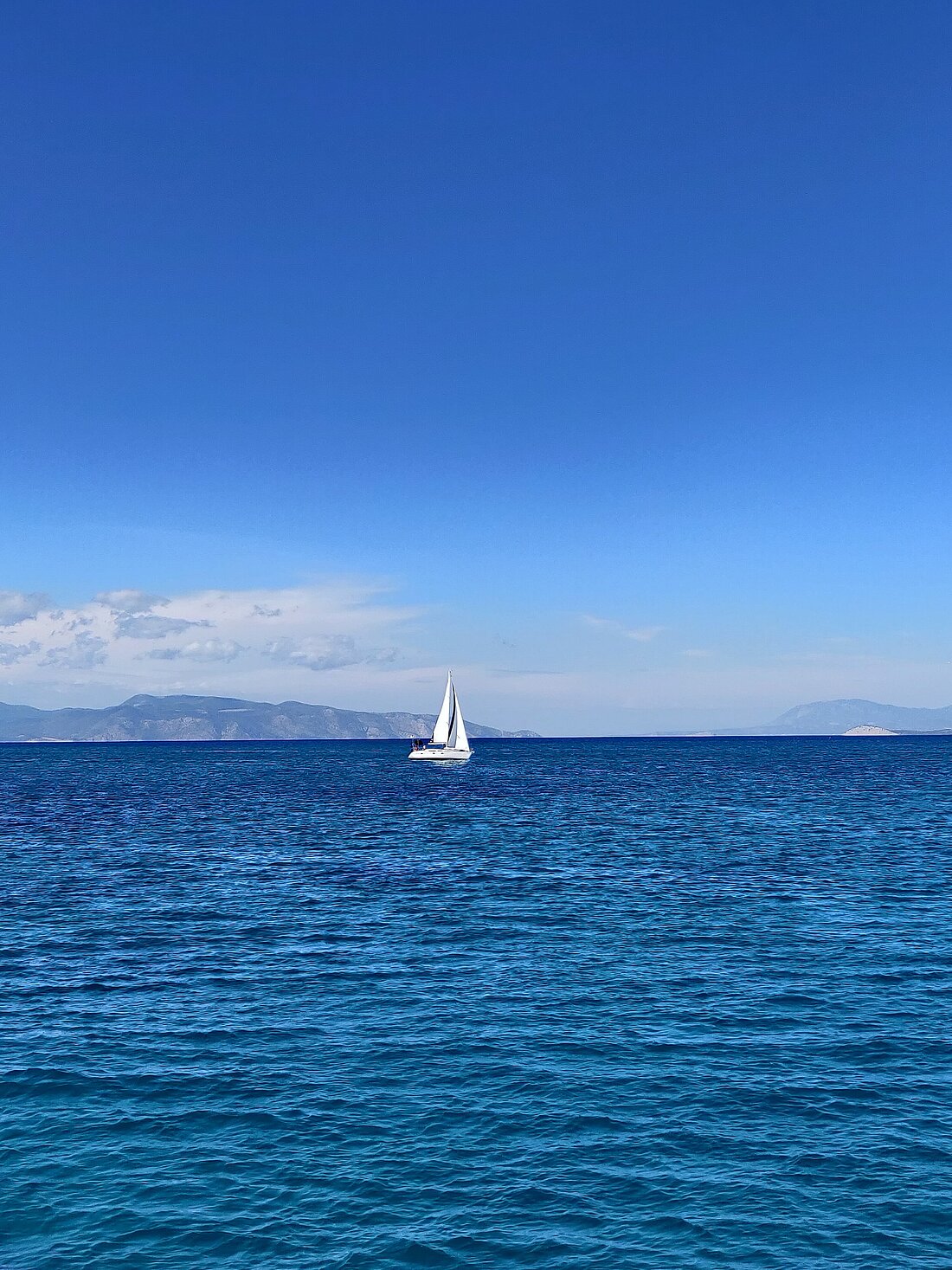 Segelboot im blauen Wasser des Saronischen Golfs bei besten Windbedingungen und gutem Wetter