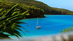 Yacht im glasklaren, blauen Meer vor Antigua umgeben von grün bewachsenen Buchten Yacht im glasklaren, blauen Meer vor Antigua umgeben von grün bewachsenen Buchten