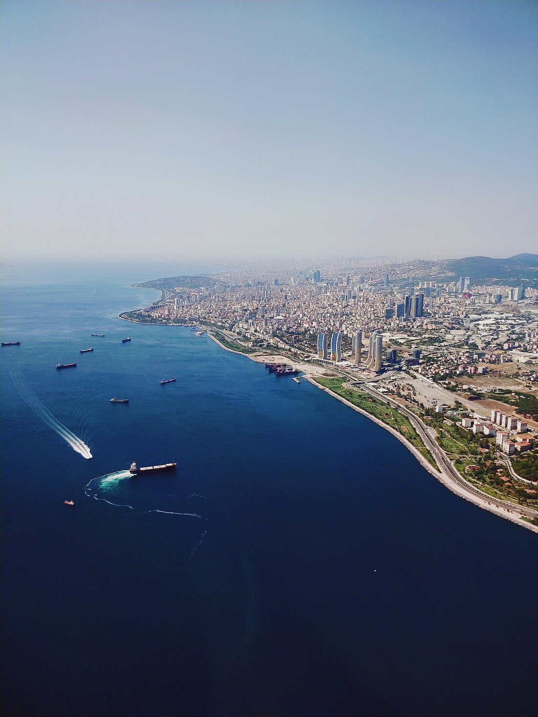 Blick von oben auf große urbanisierte Küstenstadt in der Türkei, umgeben von blauem Meer und Yachten Blick von oben auf große urbanisierte Küstenstadt in der Türkei, umgeben von blauem Meer und Yachten