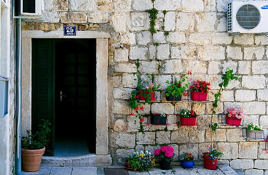 Blick von der Altstadt auf typisches mit Blumen geschmücktes Haus auf Ilovik
