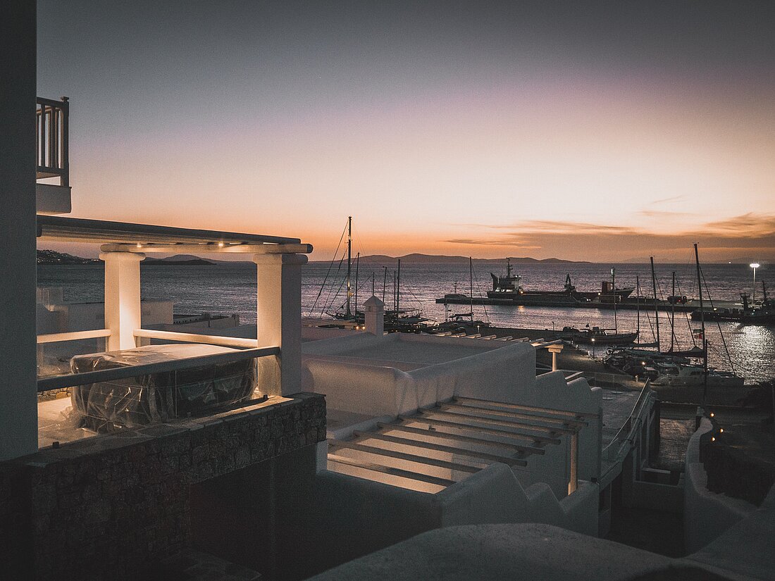 Hafen von Mykonos und ankernde Yachten, romantisch beleuchtet im Abendlicht