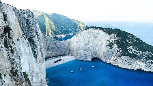 Blick auf Shipwreck Bay bei Zakynthos im Ionischen Meer, umgeben von blauem Wasser und Segelyachten