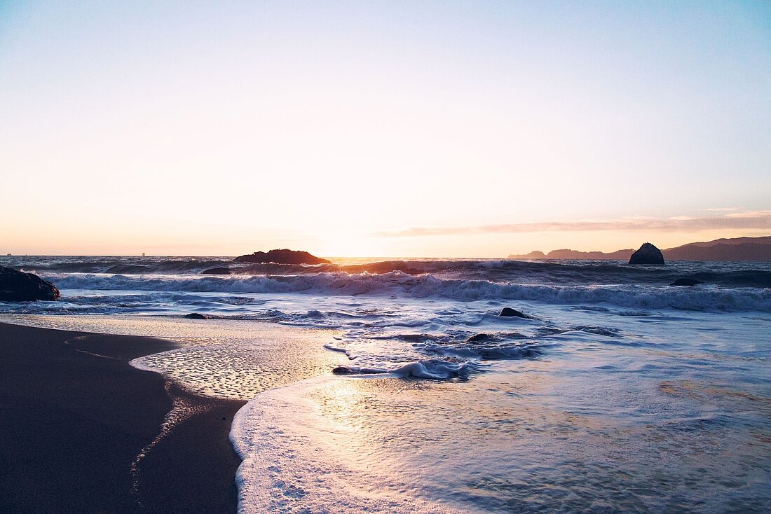 Nahaufnahme vom nassen Sand und der Gischt der Wellen an der Küste St Lucias bei Abendlicht Nahaufnahme vom nassen Sand und der Gischt der Wellen an der Küste St Lucias bei Abendlicht