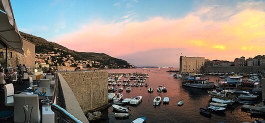 Blick vom Restaurant auf den Sonnenuntergang und eine dalmatische Marina mit Segelyachten und Booten