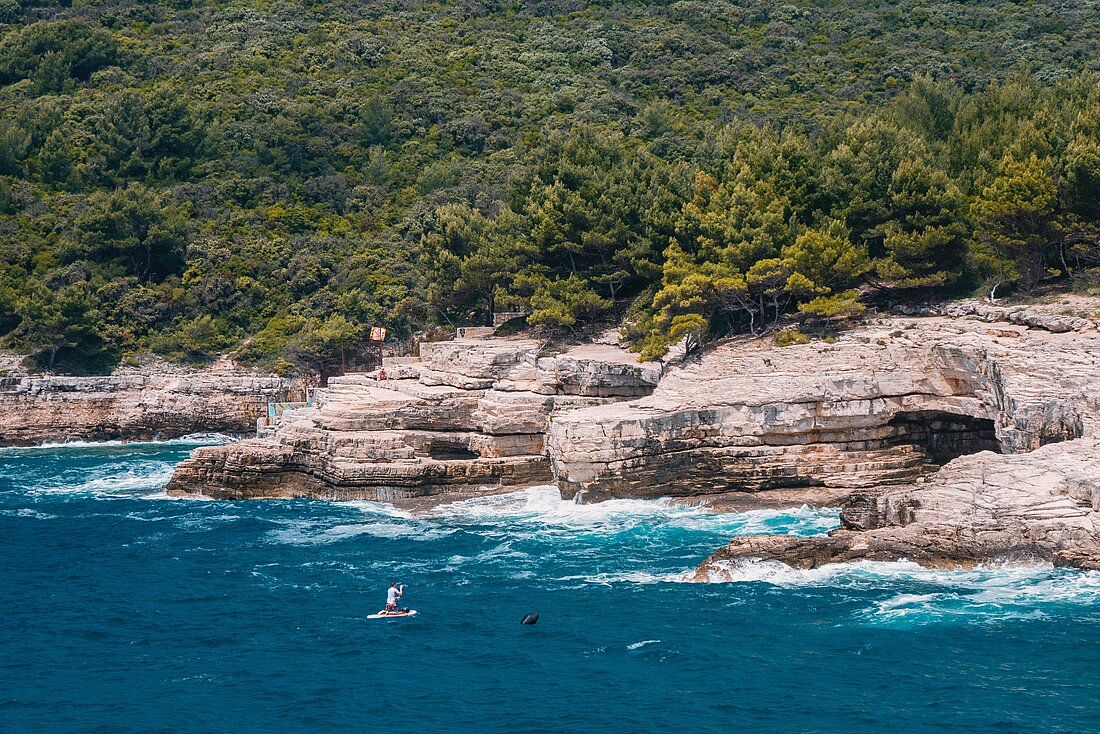 Blick von oben auf Steinbuchten und Yachten bei der Küste Pulas
