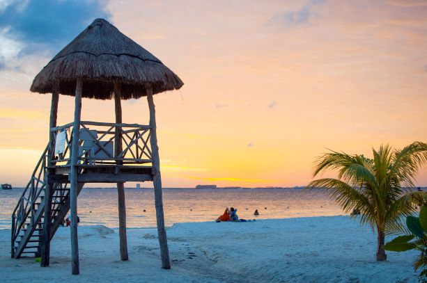Paradiesischer Sandstrand von Antigua im Sonnenuntergang mit Meeresblick und Strandhäuschen Paradiesischer Sandstrand von Antigua im Sonnenuntergang mit Meeresblick und Strandhäuschen