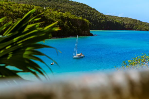 Yacht im glasklaren, blauen Meer vor Antigua umgeben von grün bewachsenen Buchten Yacht im glasklaren, blauen Meer vor Antigua umgeben von grün bewachsenen Buchten